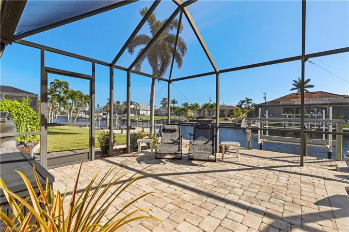 View of patio / terrace featuring a water view and glass enclosure