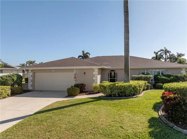 Ranch-style home featuring front yard and a garage
