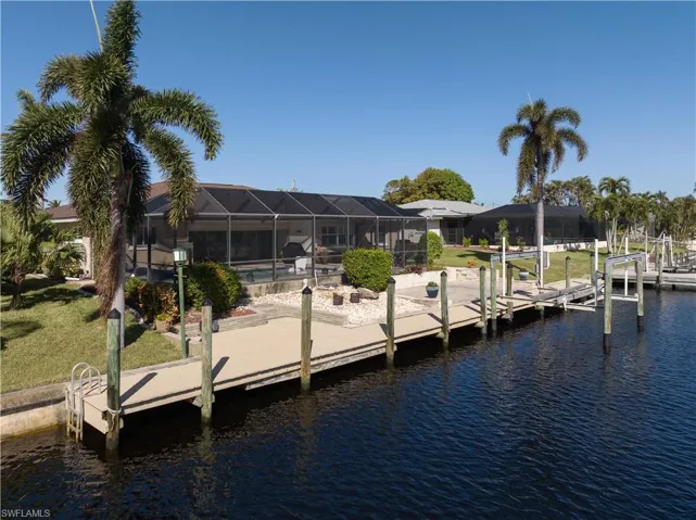 Dock area featuring a yard, a water view, and a lanai