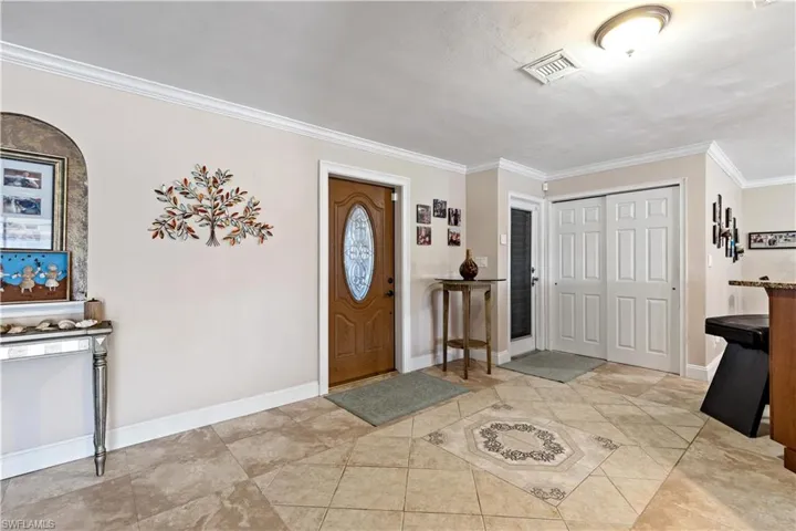 Foyer entrance featuring crown molding