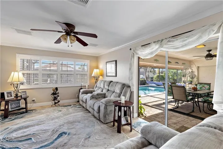 Living room featuring crown molding and ceiling fan