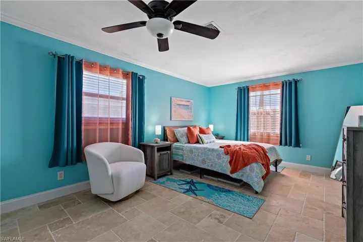 Bedroom with ceiling fan and crown molding