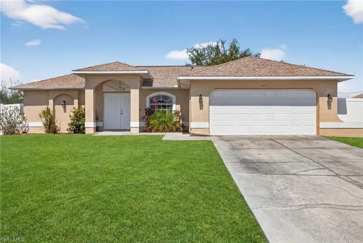 View of front of home with stucco siding, driveway, an attached garage, and roof with shingles