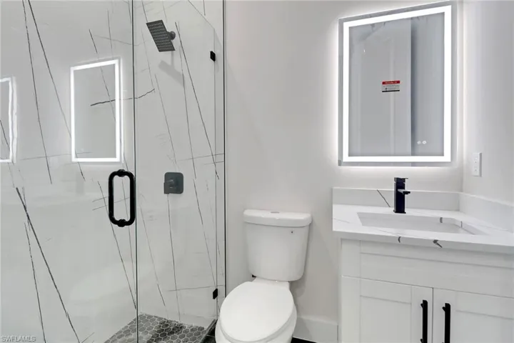 Full bathroom featuring vanity and a upgraded shower with glass door