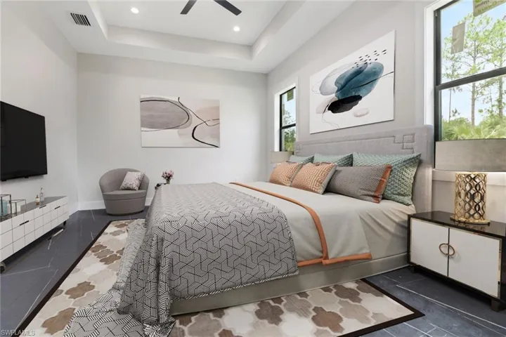 Bedroom with a raised ceiling, dark tile patterned flooring, ceiling fan, and recessed lighting