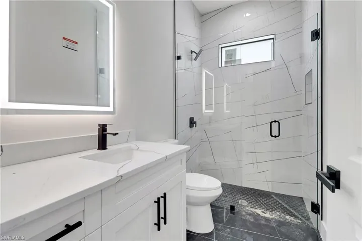 Guest bathroom featuring upgraded vanity and shower with frameless glass enclosed shower
