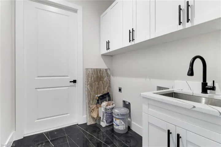 Laundry room with washer / dryer hookup, abundant cabinet space, laundry sink and tile floors