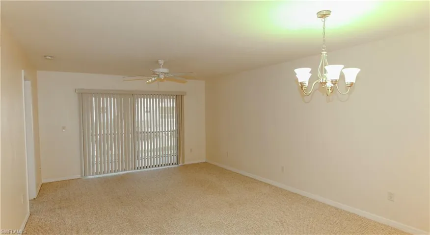 Unfurnished room with light carpet, a ceiling fan, and a chandelier