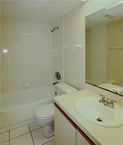 Full bath featuring vanity, bathtub / shower combination, and light tile patterned floors