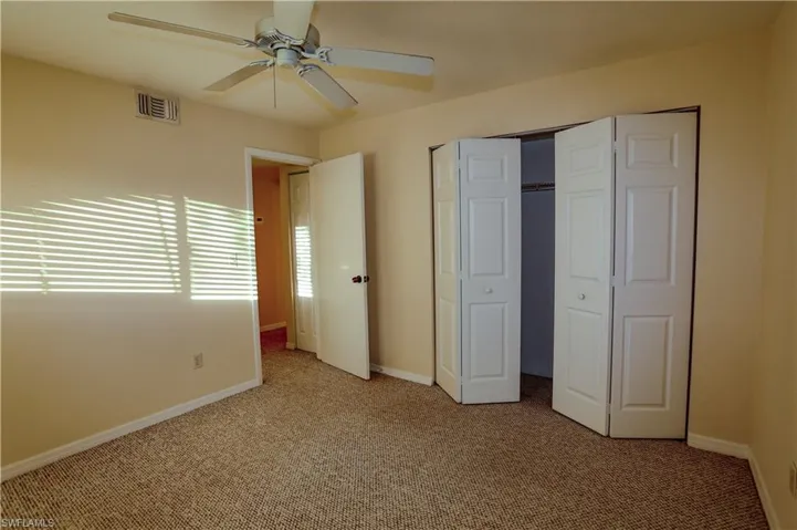 Unfurnished bedroom featuring carpet, a closet, and a ceiling fan