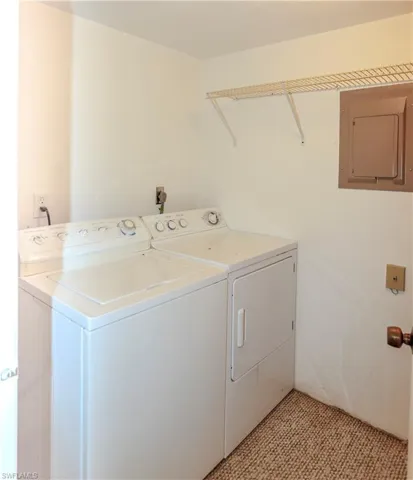 Laundry area featuring electric panel and independent washer and dryer