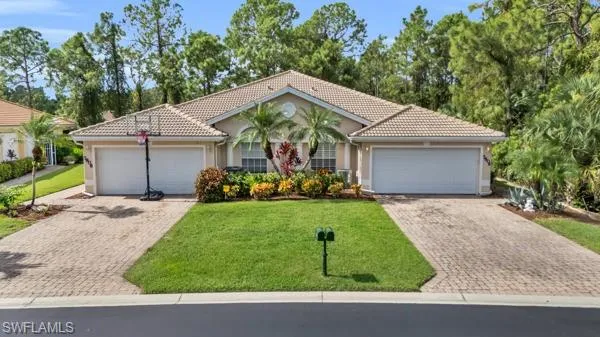 View of front facade featuring a front yard and a garage