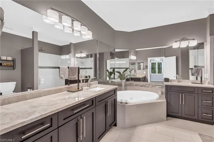 Full bathroom featuring vanity, shower with separate bathtub, tile patterned flooring, and toilet
