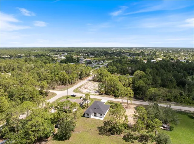 Aerial view of property and surrounding area with a heavily wooded area