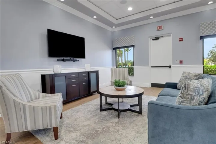 Living room featuring light wood-style flooring, recessed lighting, a paneled ceiling, and a tray ceiling
