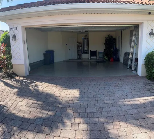 Garage with decorative driveway and water heater