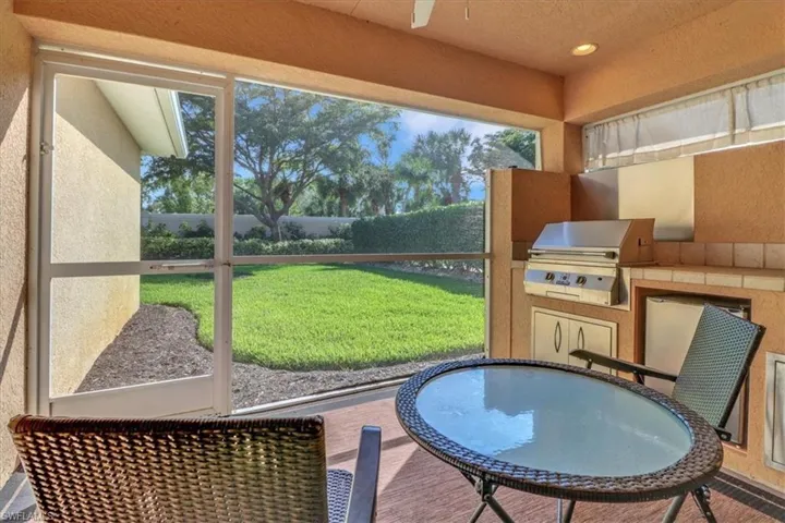 Sunroom with exterior kitchen, outdoor dining space, a patio area, and healthy amount of natural light