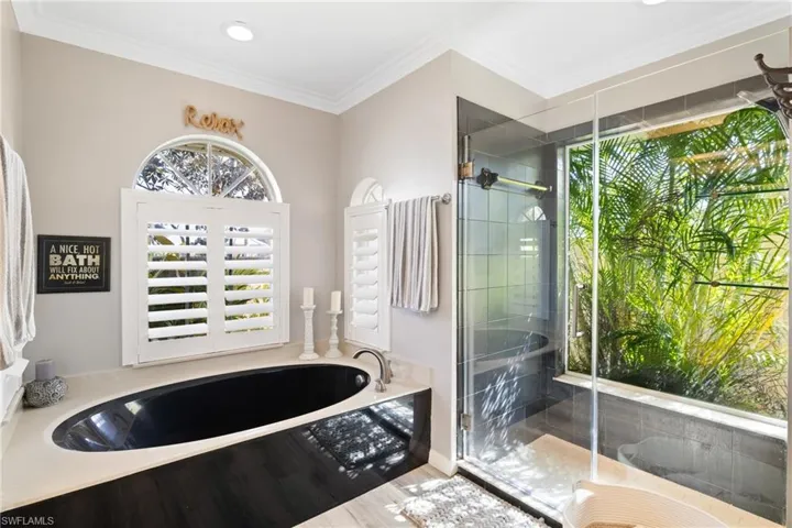 Bathroom with ornamental molding and plus walk in shower