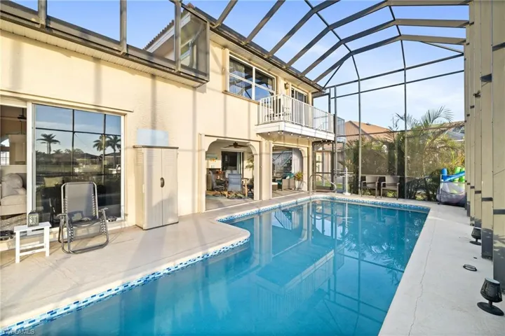 View of pool featuring glass enclosure and a patio area