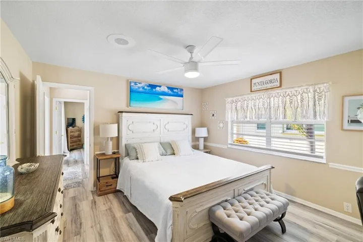 Bedroom featuring ceiling fan, a textured ceiling, and light hardwood / wood-style floors