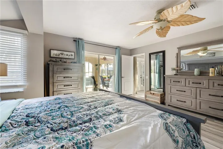 Bedroom with ceiling fan, light wood-type flooring, access to outside, and multiple windows