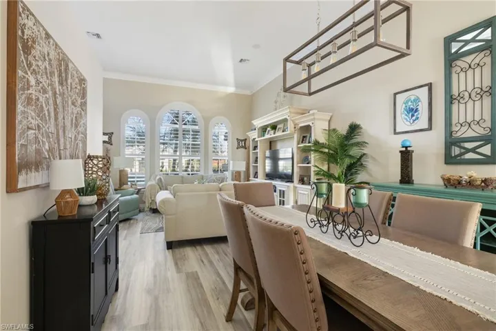 Dining area with light hardwood / wood-style flooring and crown molding
