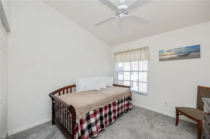 Bedroom with vaulted ceiling, ceiling fan, and light colored carpet