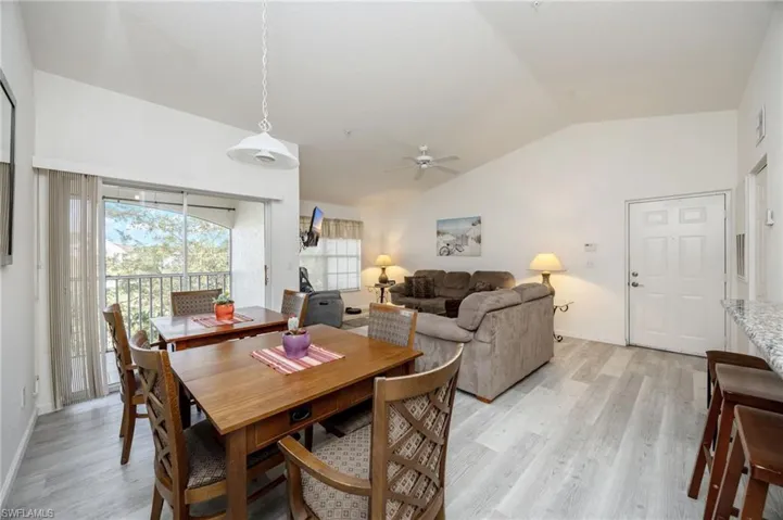 Dining area with lofted ceiling, light wood finished floors, and ceiling fan