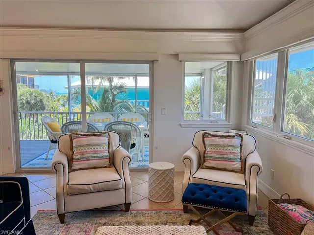 Tiled living room with crown molding and a water view