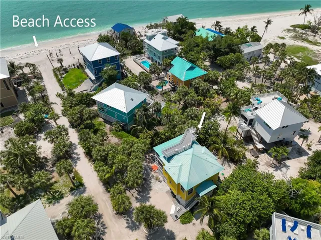 Birds eye view of property with a beach view and a water view