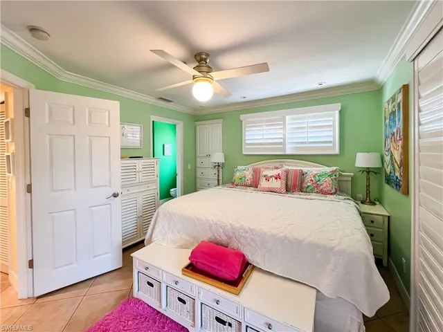 Bedroom with crown molding, ceiling fan, and light tile floors