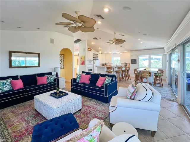 Tiled living room with vaulted ceiling and ceiling fan