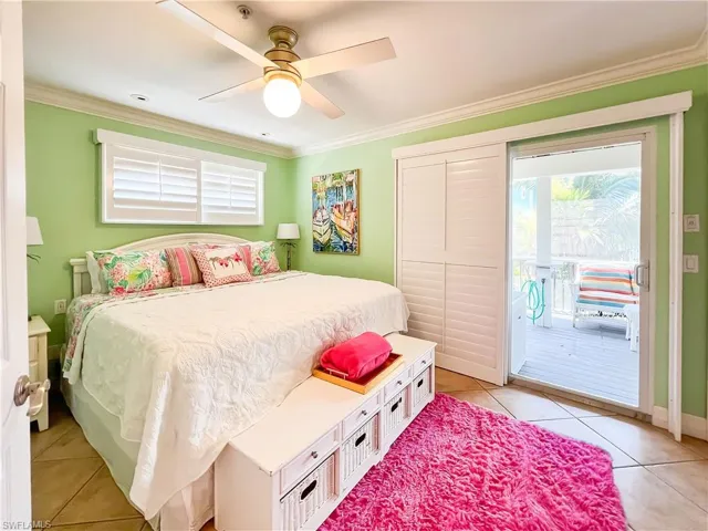 Tiled bedroom featuring ceiling fan, access to exterior, and crown molding