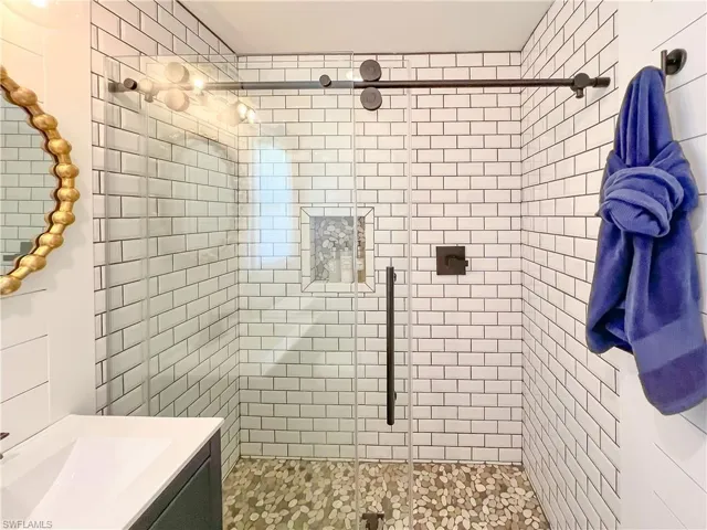 Bathroom with tiled shower and vanity