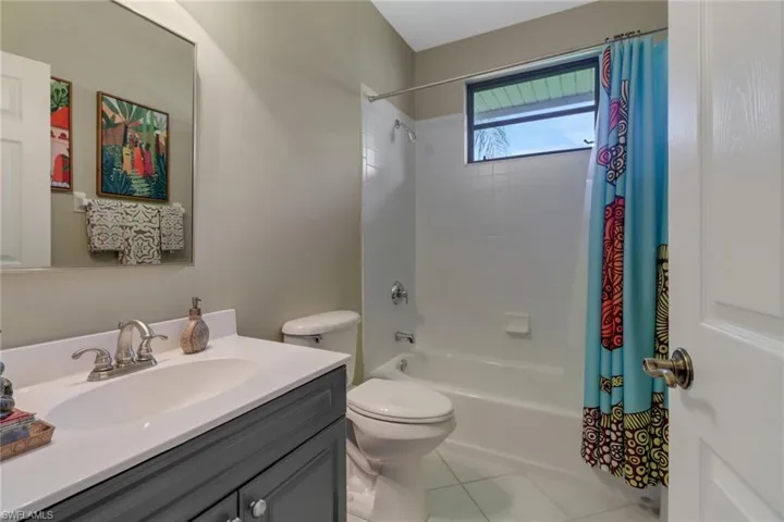 Full bathroom with shower / tub combo, tile patterned floors, vanity, and toilet
