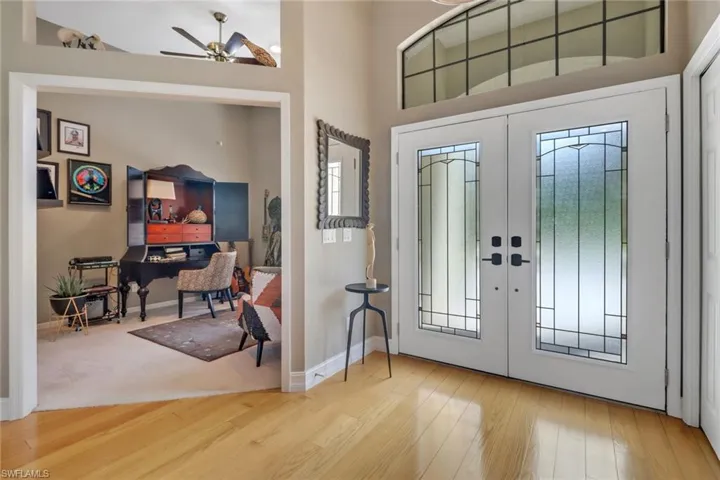 Entrance foyer featuring hardwood / wood-style floors, ceiling fan, french doors, and high vaulted ceiling