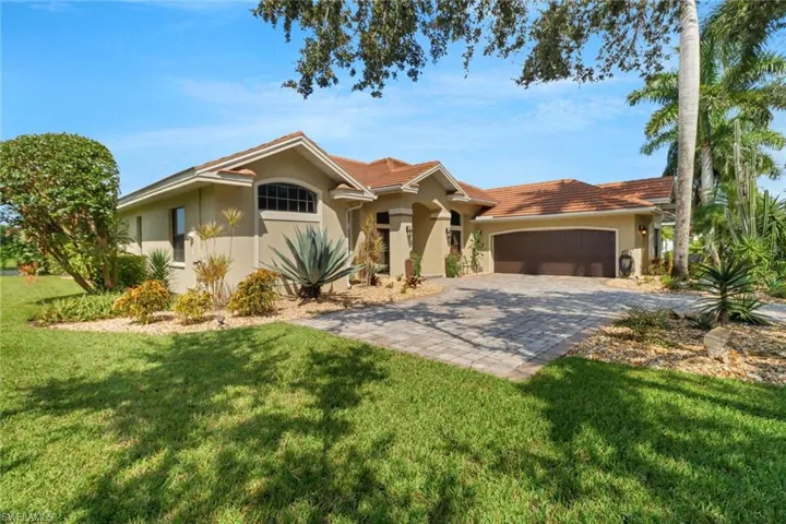 Ranch-style house featuring a garage and a front lawn