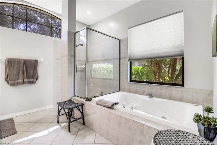 Bathroom with independent shower and bath and tile patterned floors