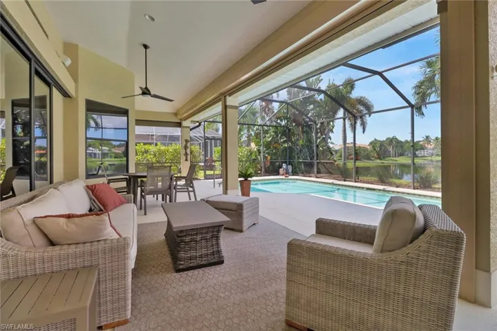 View of pool with a lanai, a water view, and an outdoor living space
