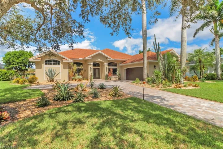 Mediterranean / spanish home with a front yard and a garage