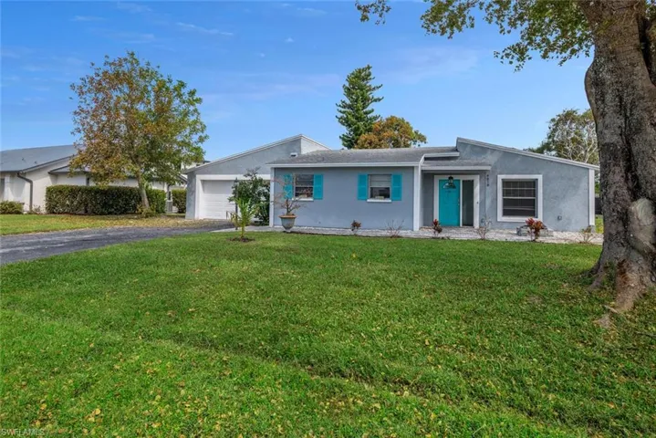 Ranch-style house featuring a front lawn and a garage