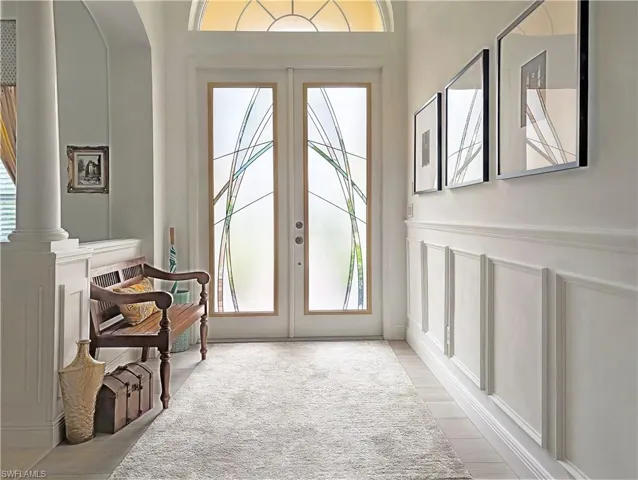 Entryway featuring a decorative wall, french doors, and a wainscoted wall