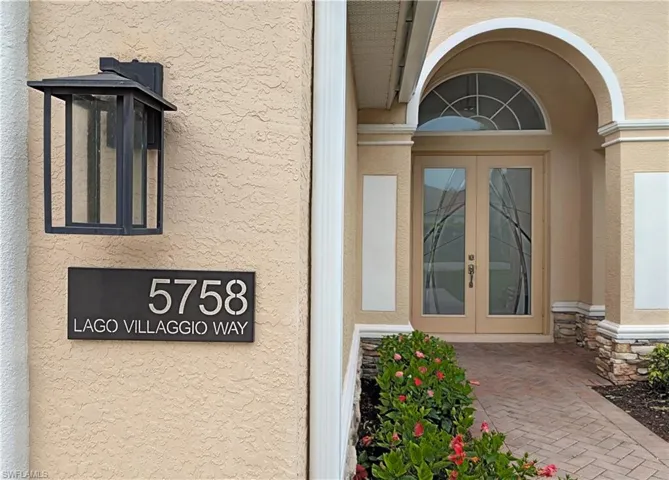 Doorway to property featuring stucco siding, stone siding, and french doors