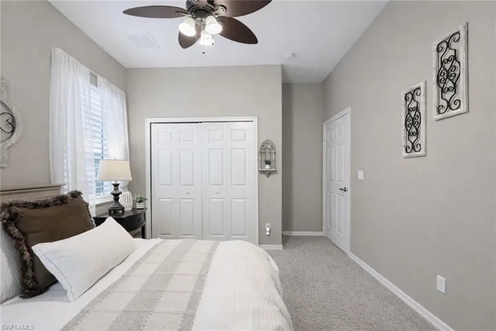 Bedroom featuring light grey walls, white trim, and light-colored carpet flooring