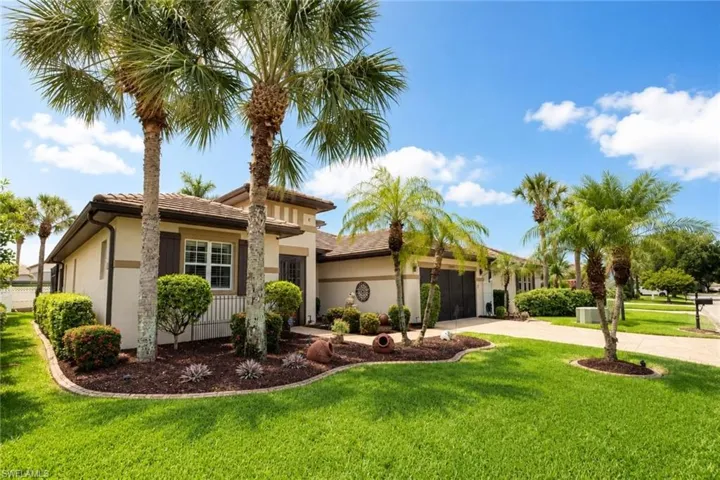 Exterior stucco residence featuring a tile roof and decorative window shutters