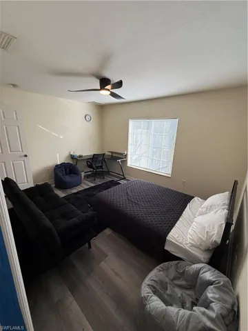 Living area with wood finished floors, a ceiling fan, and a desk