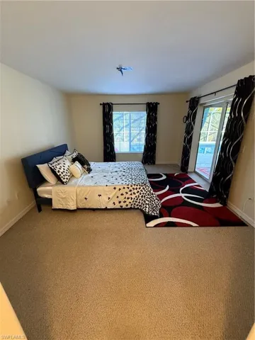 Bedroom featuring carpet and multiple windows