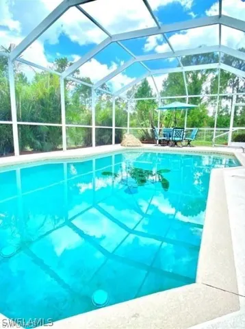 Swimming pool featuring glass enclosure and a sunroom