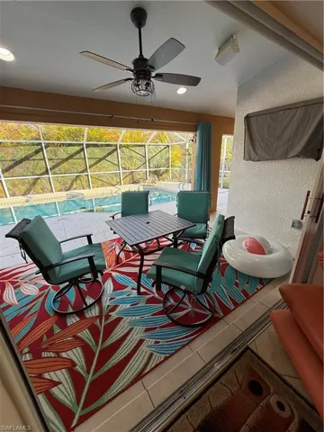 View of patio featuring glass enclosure, a ceiling fan, an outdoor pool, and a sunroom