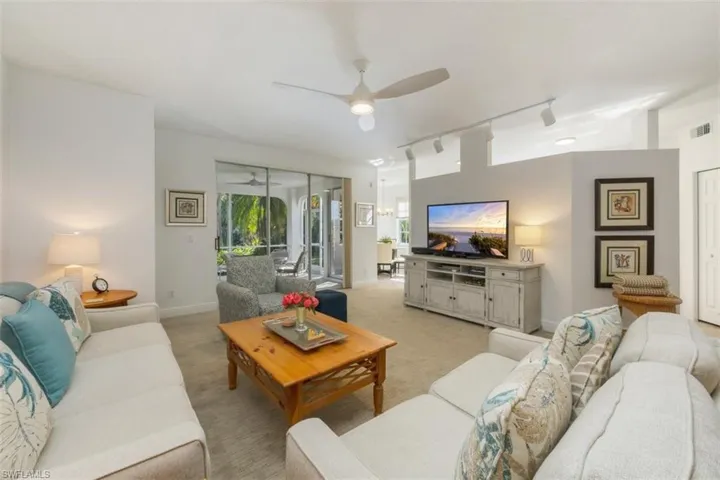 Living area featuring rail lighting, carpet floors, and a ceiling fan